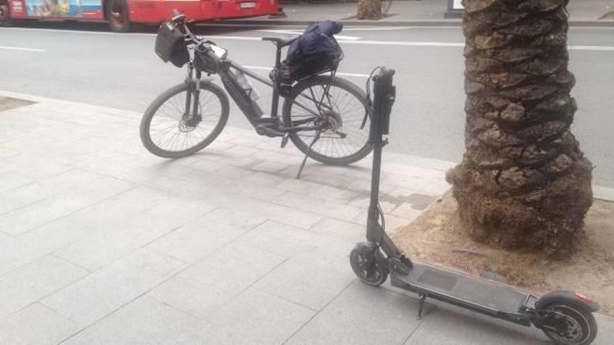 La bicicleta de uno de los policías locales y el patinete sancionado el pasado abril en una calle de Alicante