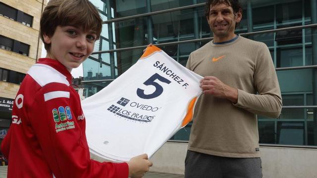 Diego Sánchez y su hijo Nel sujetan una de las camisetas del Oviedo Baloncesto que vistió en su etapa como jugador del club asturiano. |