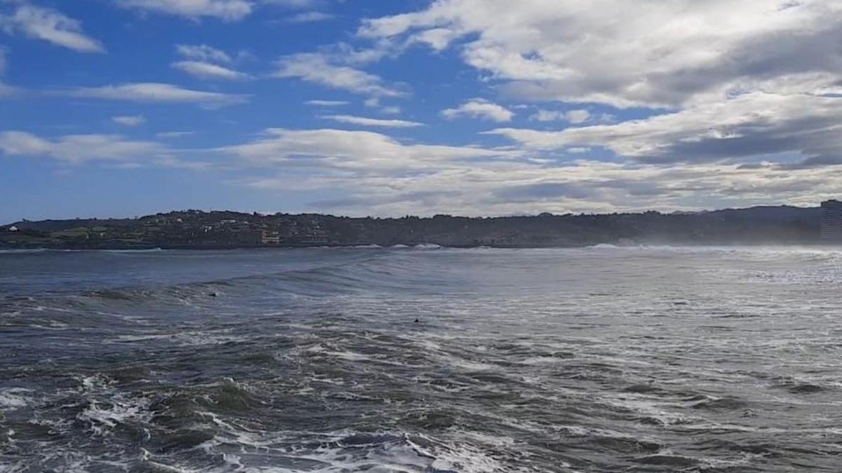 Surfistas esta mañana en la playa de San Lorenzo de Gijón.