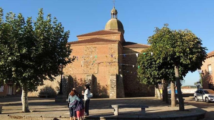 Varias personas en la plaza de la iglesia de Santa Cristina.