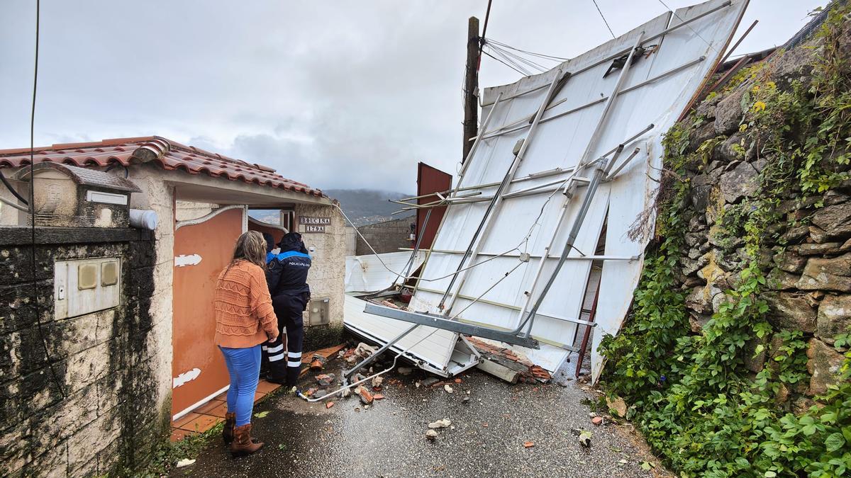 La cubierta del garaje que salió despedida por el tornado bloqueó el paso en el Camiño da Moureira, en Meira.