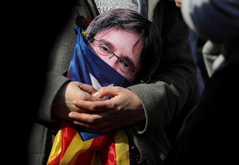 Un independentista sostiene una máscara de Carles Puigdemont.