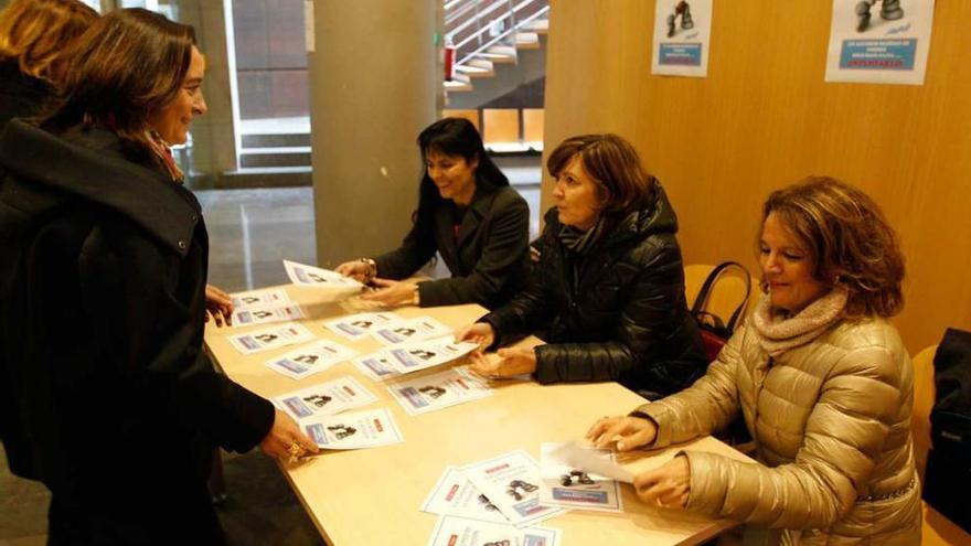 Sentadas, la abogada Manuela Rodríguez, Margarita Fuente y Carmen Trelles, repartiendo información.