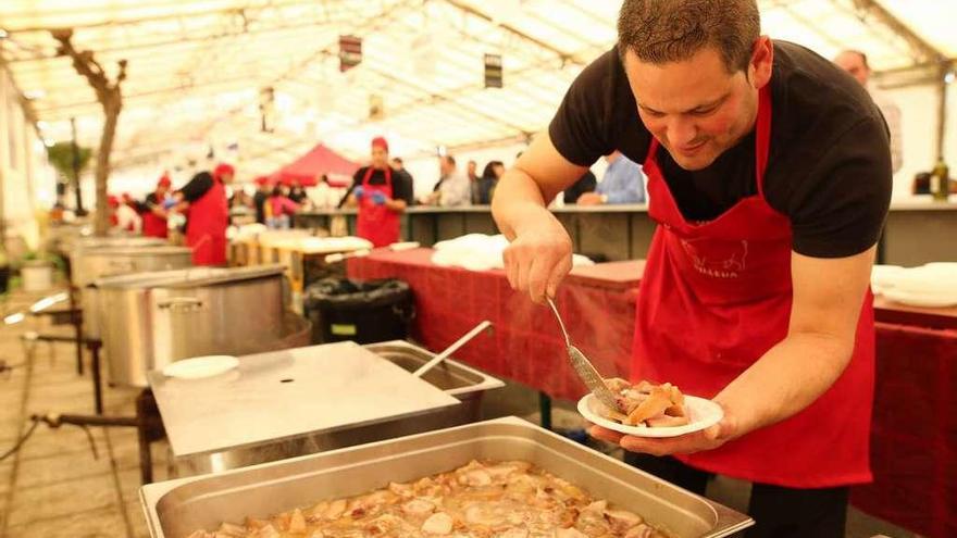 Un miembro de la organización prepara una ración en la Festa do Porco del año pasado.  // Bernabé