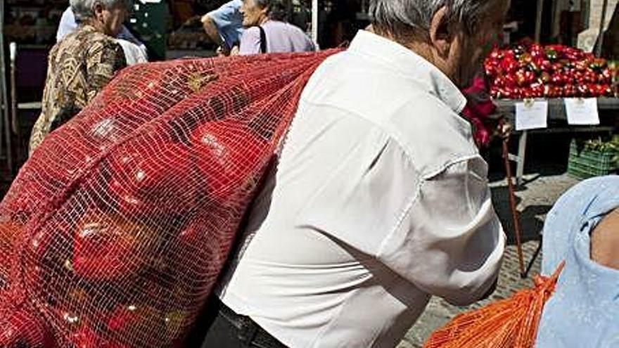 Un hombre carga con un saco de pimientos en una edición de la feria benaventana. A. G.