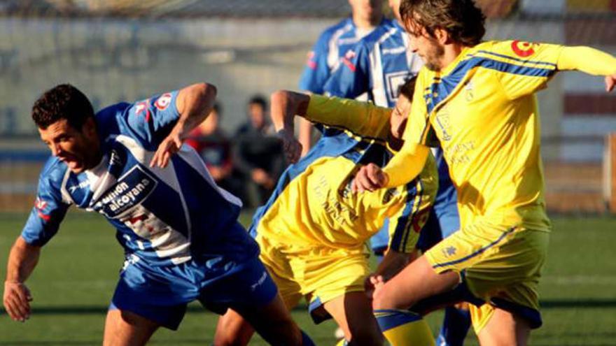 Un jugador del Dénia busca el esférico ante un rival.