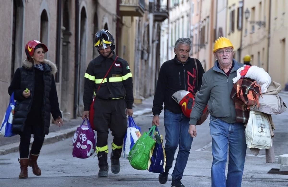 jcarbo36100149 a firefighter helps residents to carry their belongings foll161031115255