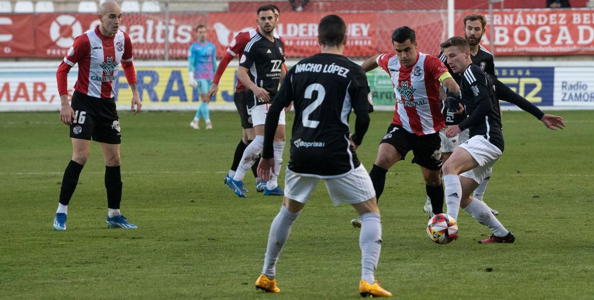 Dani, rodeado de jugadores del Langreo. |  | JOSÉ LUIS FERNÁNDEZ