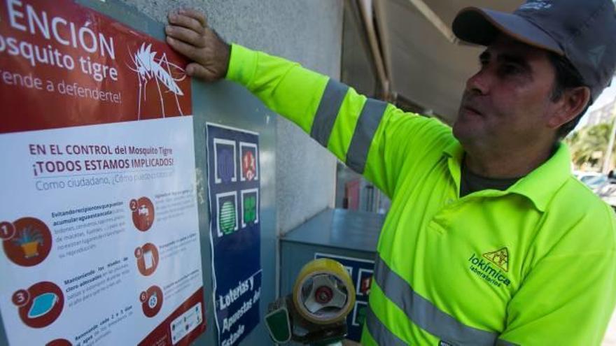 Un operario coloca carteles con consejos en la zona de playas, ayer