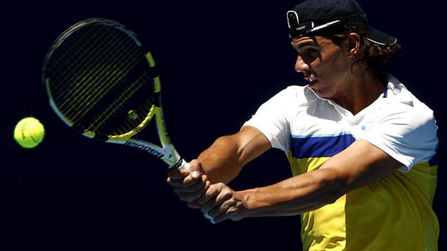 El tenista español Rafael Nadal devuelve una bola durante una sesión de práctica previa al Abierto de Australia que comienza el próximo lunes en Melbourne.