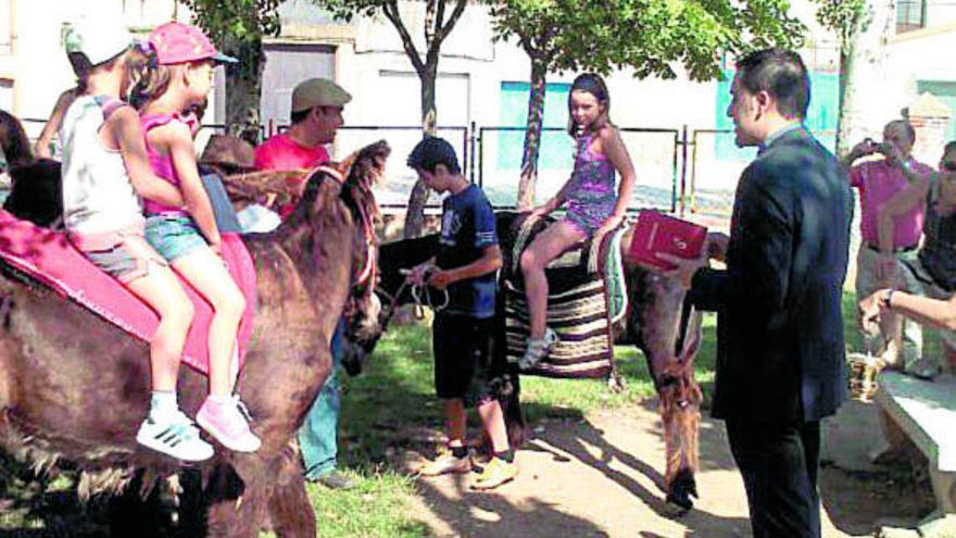 El párroco de Morales de Toro bendice a los burros antes de comenzar la primera ruta enoturística.