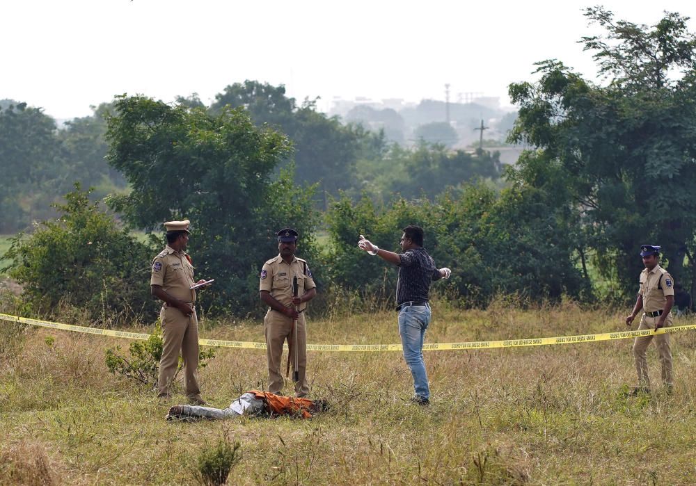 Police officers stand next to the body of a man ...