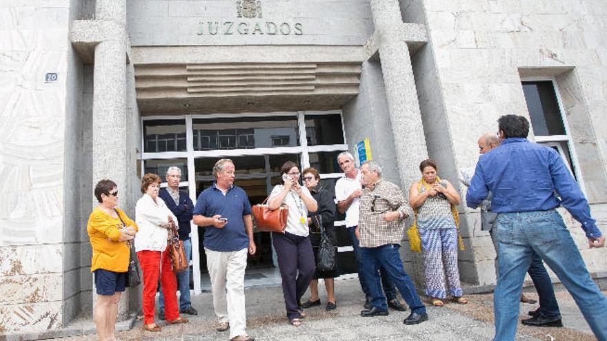 Manuel Jiménez del Valle, en el centro con camisa azul, sale del Juzgado.