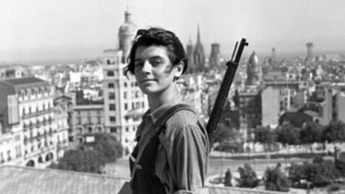 La mítica foto de Marina Ginestà, a los 17 años, vestida de miliciana y con el fusil al hombro, en la azotea del hotel Colón, en la plaza de Catalunya de Barcelona, al comienzo de la guerra civil.