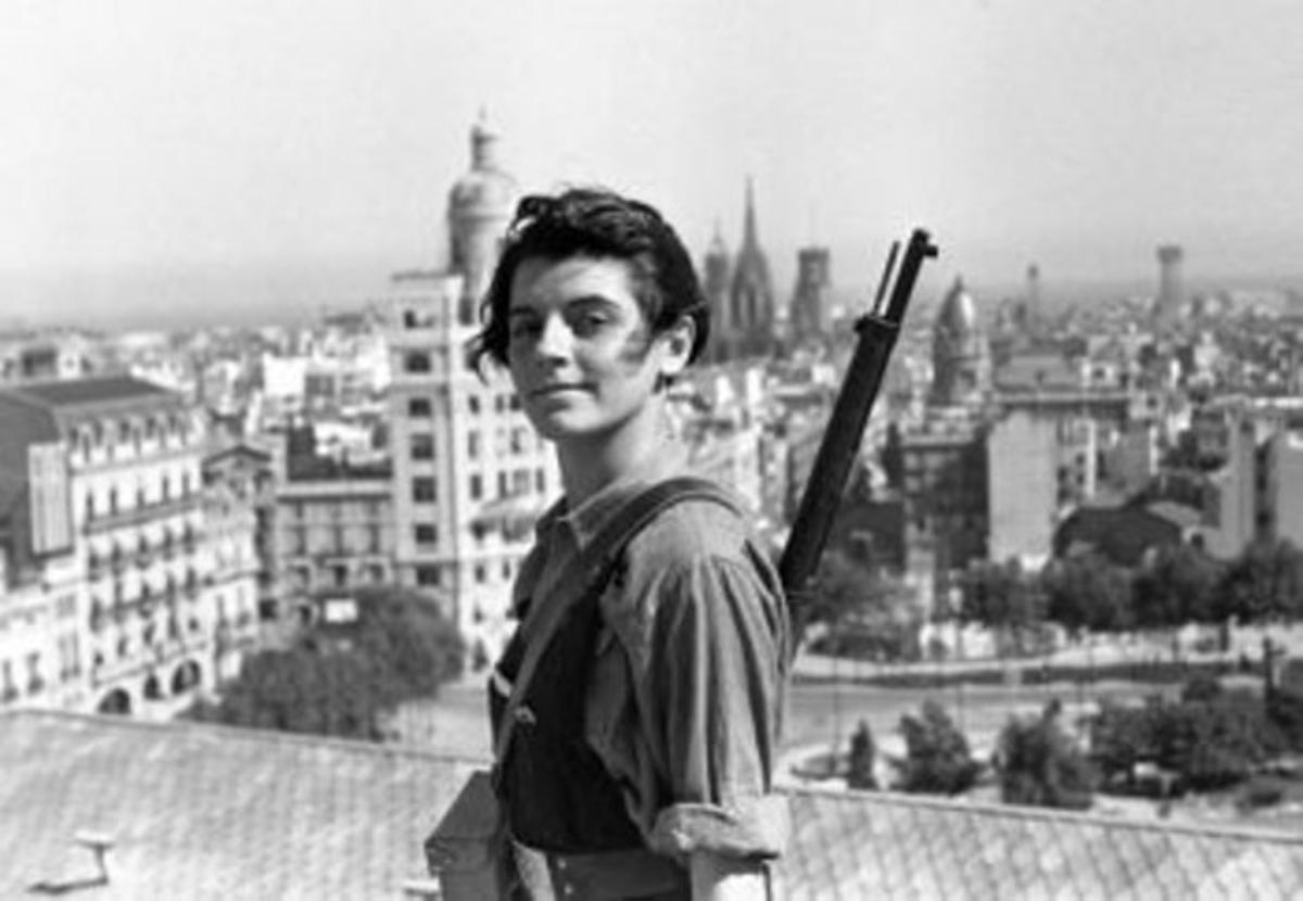 La mítica foto de Marina Ginestà, als 17 anys, vestida de miliciana i amb el fusell a l’espatlla, al terrat de l’hotel Colón, a la plaça de Catalunya de Barcelona, al començament de la guerra civil.