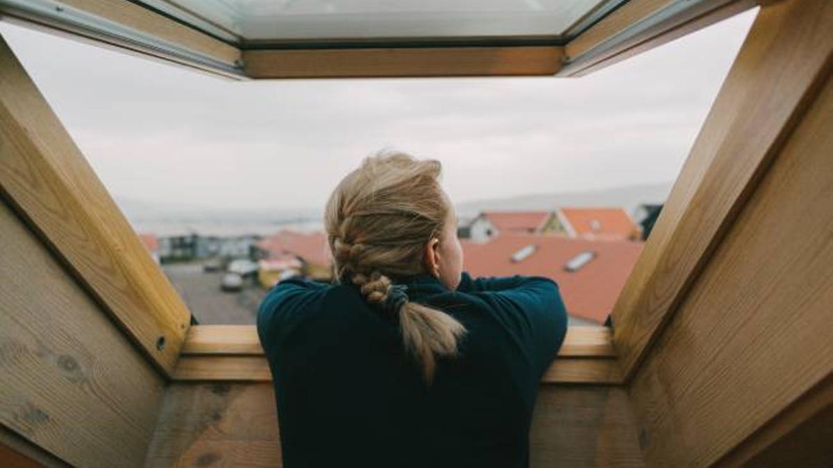 Mujer asomada a la ventana