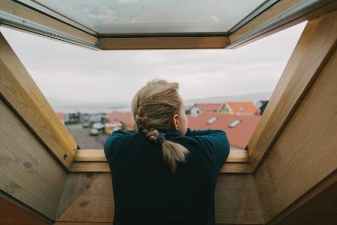 Mujer asomada a la ventana