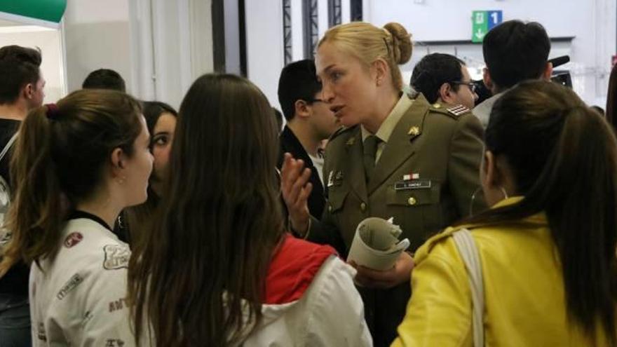 Una militar conversa amb diversos estudiants.