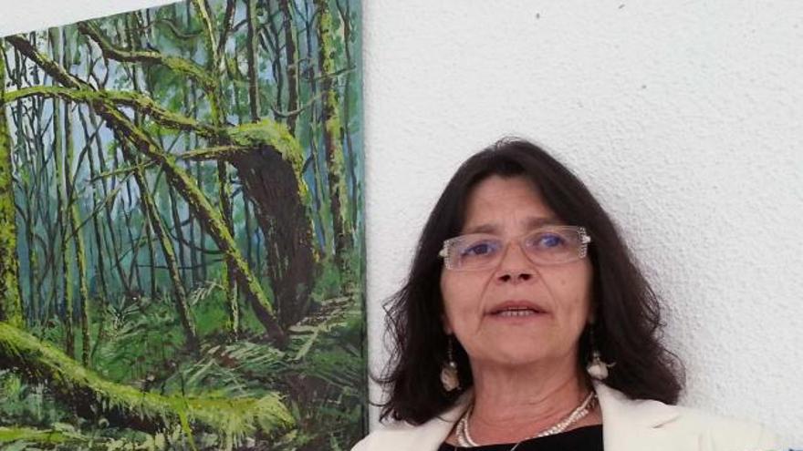 Carmen Muñiz, con dos cuadros de su exposición.