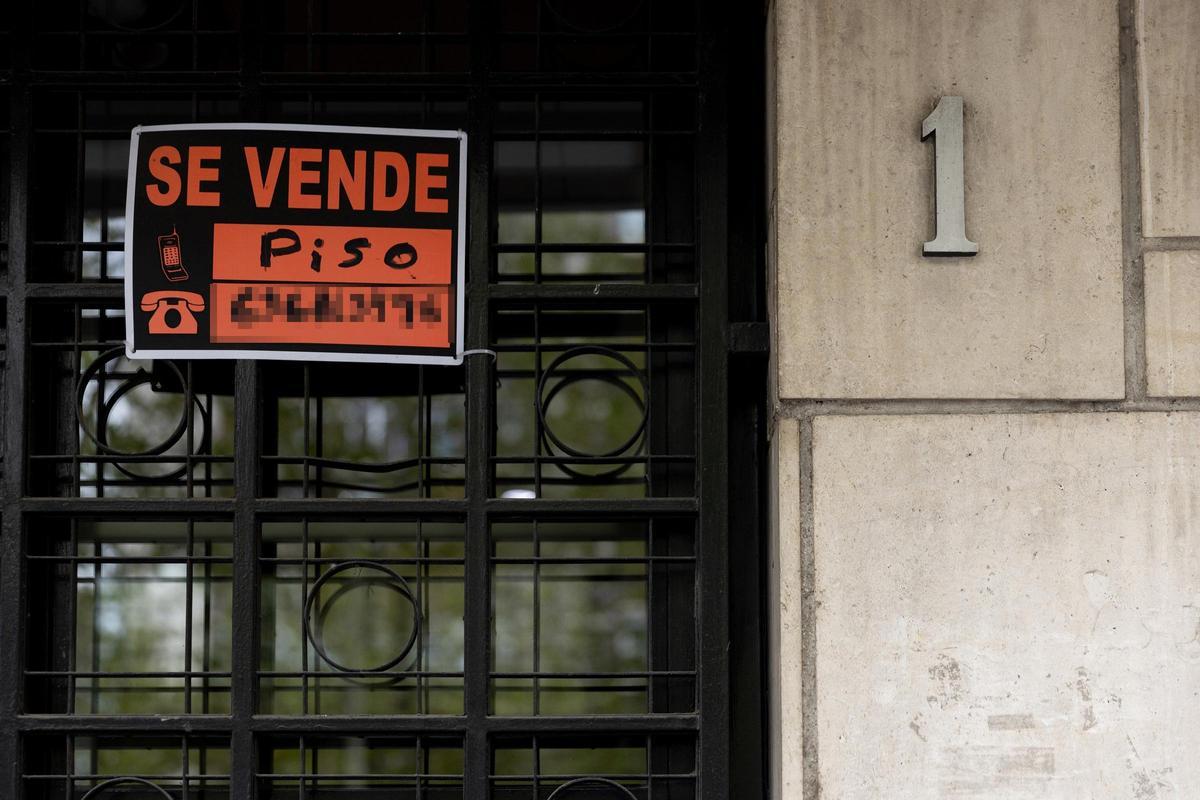 Archivo - Vista de un cartel de 'Se vende' en un portal de un edificio de viviendas