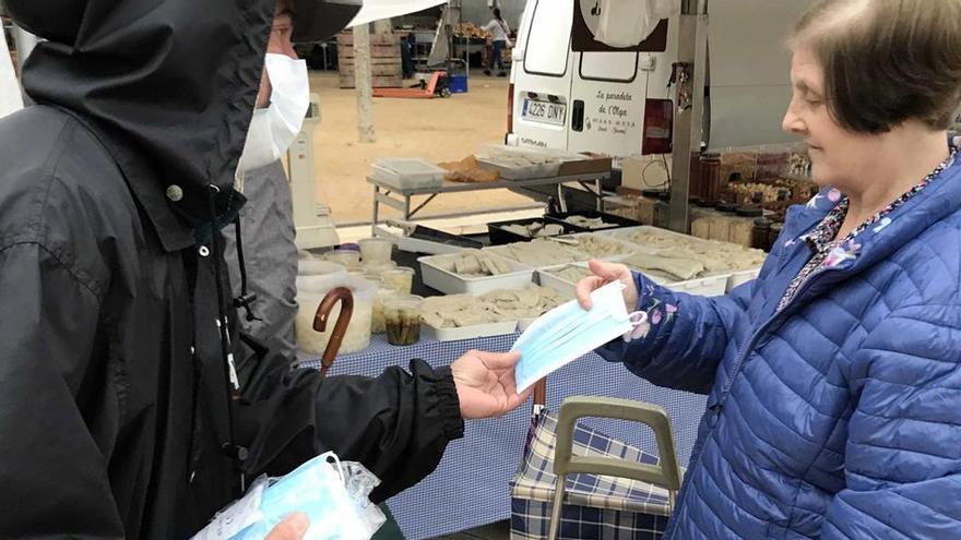 Un voluntari repartint mascaretes al Mercat de Banyoles, ahir