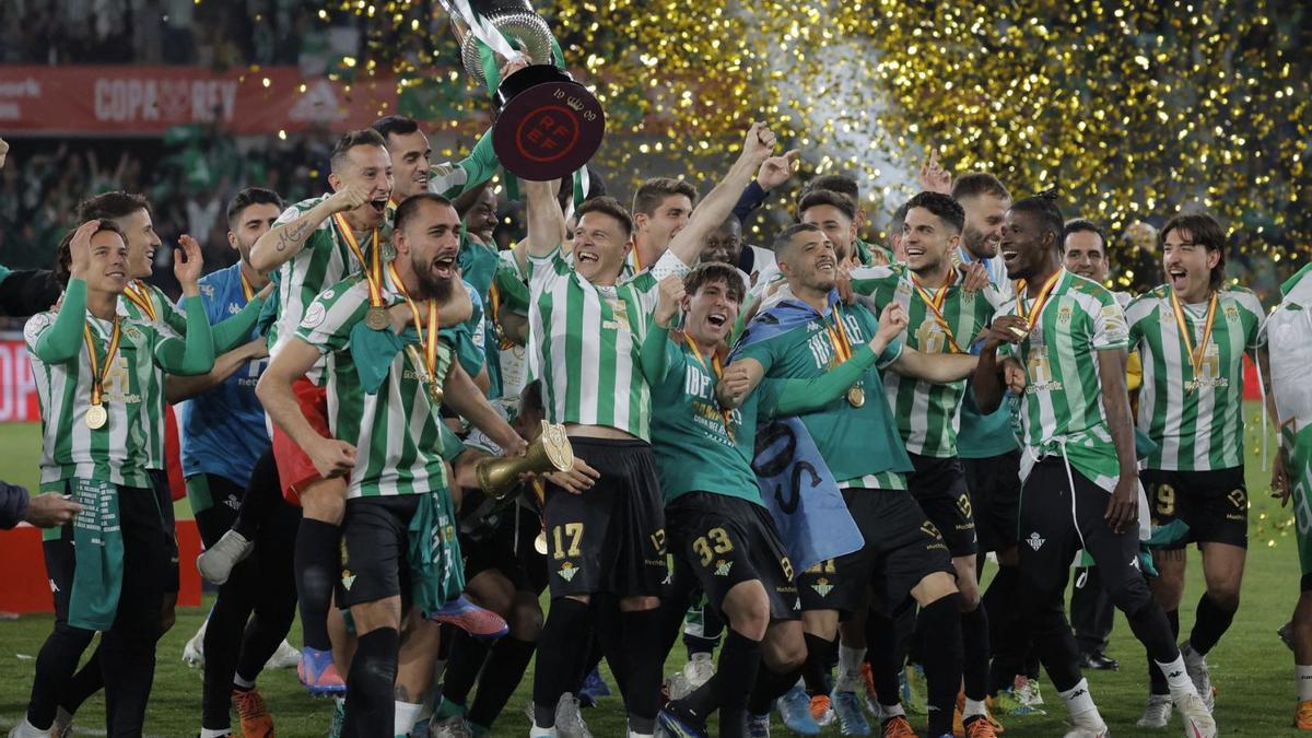 Joaquín, rodeado de sus compañeros, levanta el trofeo de Copa del Rey sobre el césped del estadio de La Cartuja. // JON NAZCA