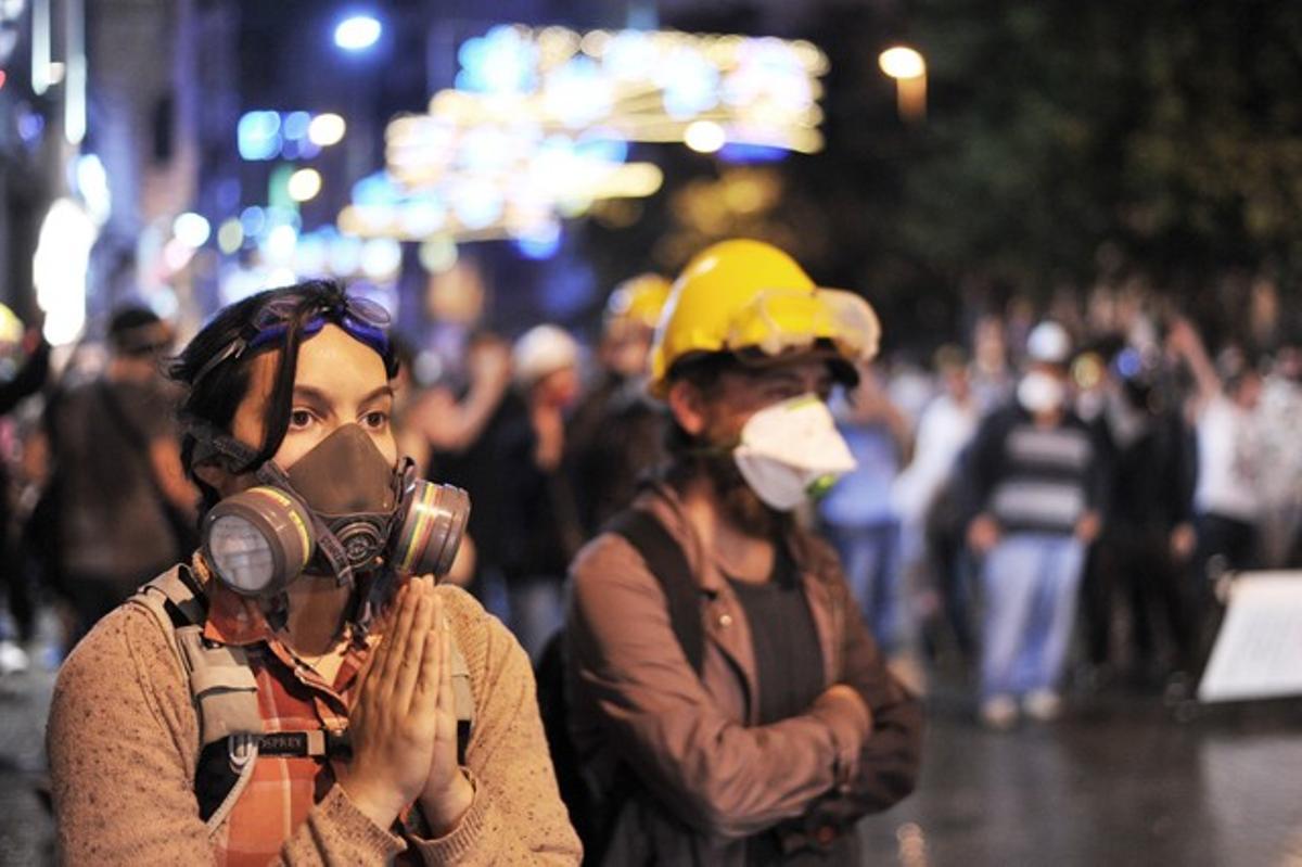 Una manifestant amb màscara antigàs prega als antiavalots que no usin gas lacrimogen, dissabte al carrer Istiklal d’Istanbul.