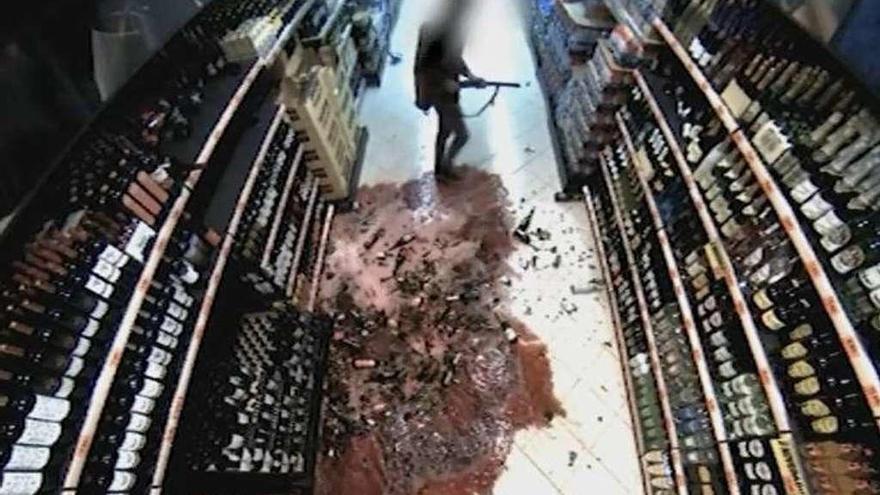 El investigado, con la escopeta en ristre, tras derramar varias botellas, en una imagen de seguridad. // FdV