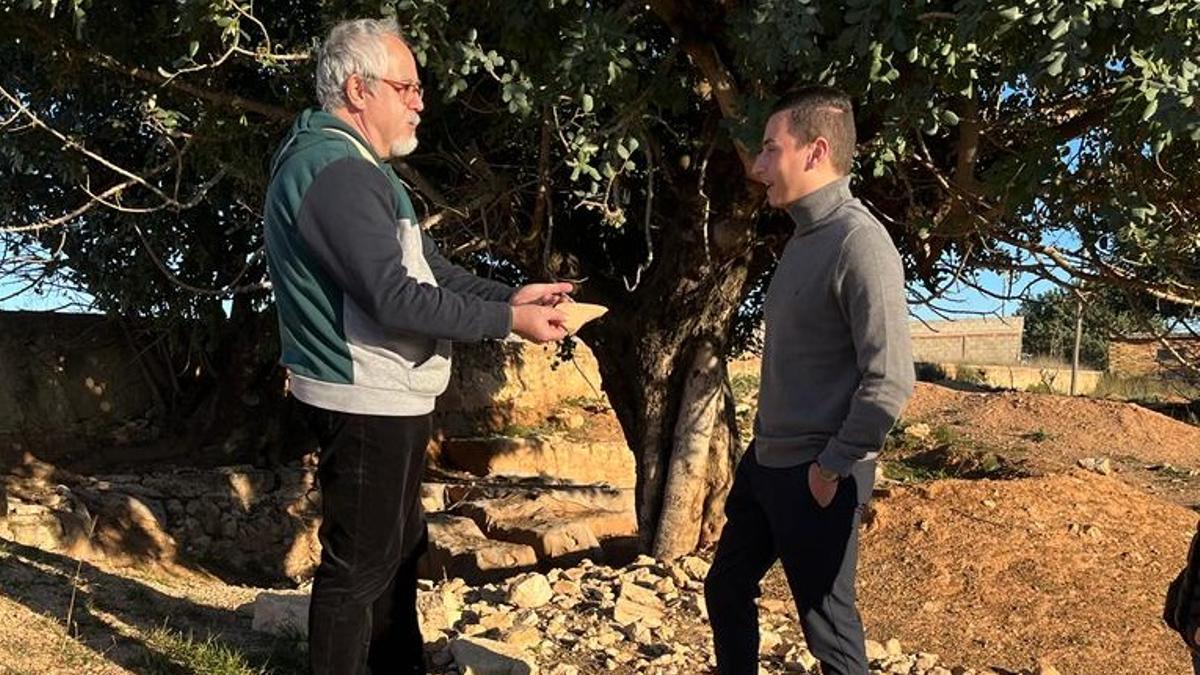 El candidato del PP, junto a restos del yacimiento, y un investigador local.