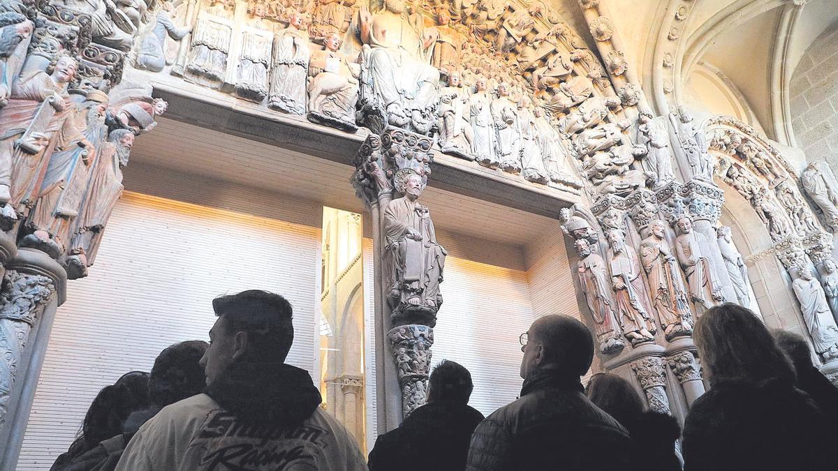 Visitantes contemplan el Pórtico de la Gloria de Santiago, completamente restaurado .