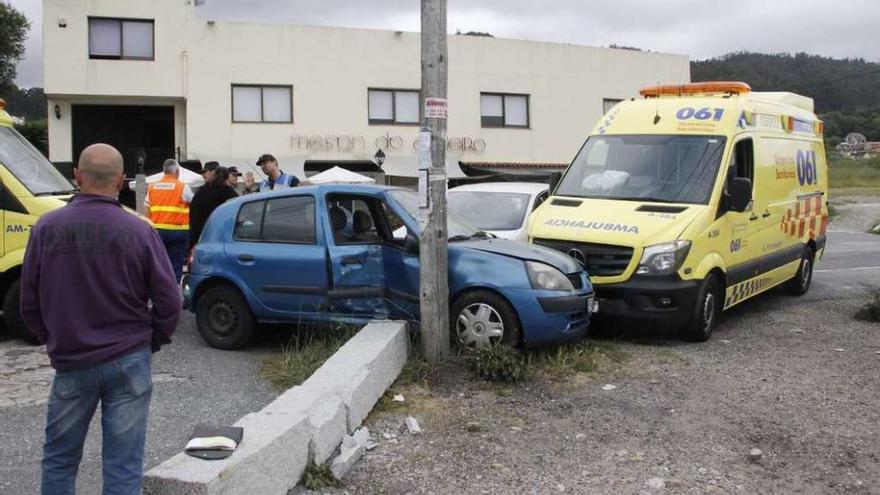 La ambulancia accidentada, junto a otro de los coches implicados y el poste derribado. // S, Álvarez