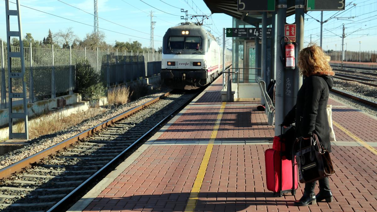 Pla general d'una viatgera esperant a l'andana de l'estació de l'Aldea-Tortosa-Amposta un dels Talgo que ha arribat amb retard. Imatge del 13 de gener del 2020 (horitzontal)