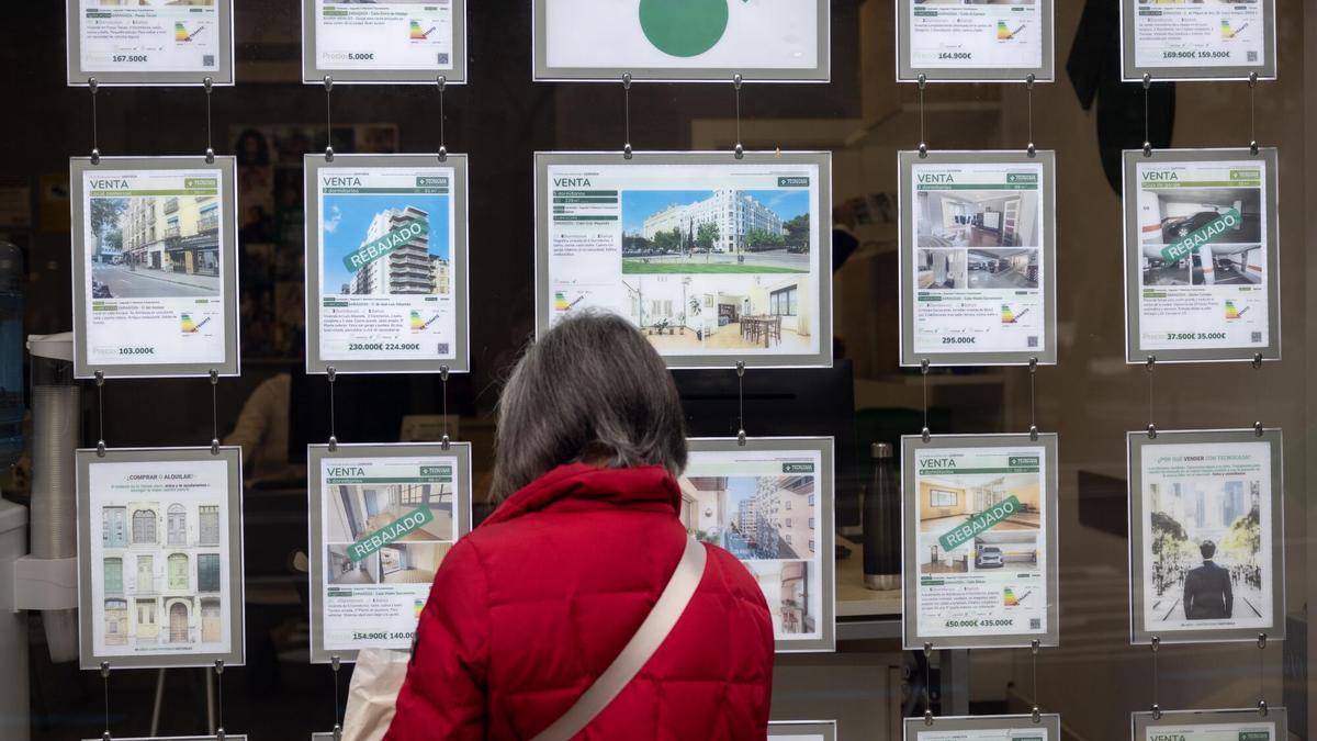 Una mujer ojea los precios en un escaparate.