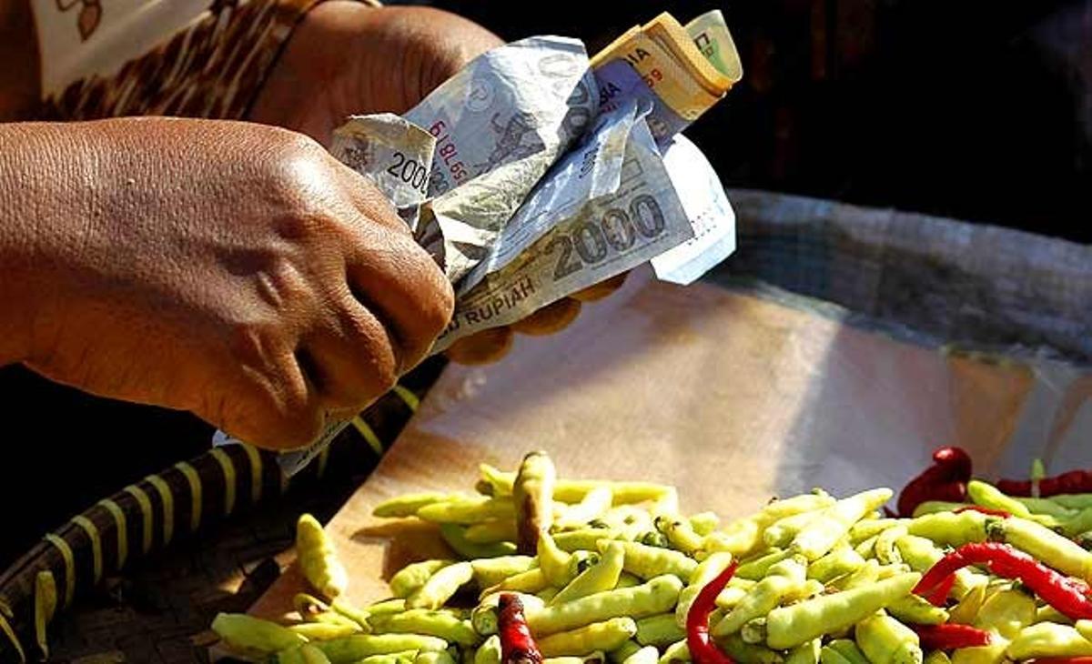 Un venedor de xili compta bitllets en un mercat al sud de Jakarta (Indonèsia).