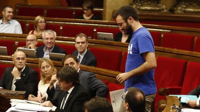 El diputado de la CUP Albert Botran pasa junto al 'president' Carles Puigdemont.