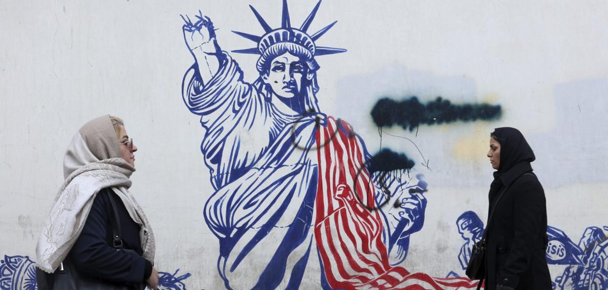 Iraníes caminan junto a un mural antiestadounidense en una calle de Teherán, Irán, el 24 de enero de 2026