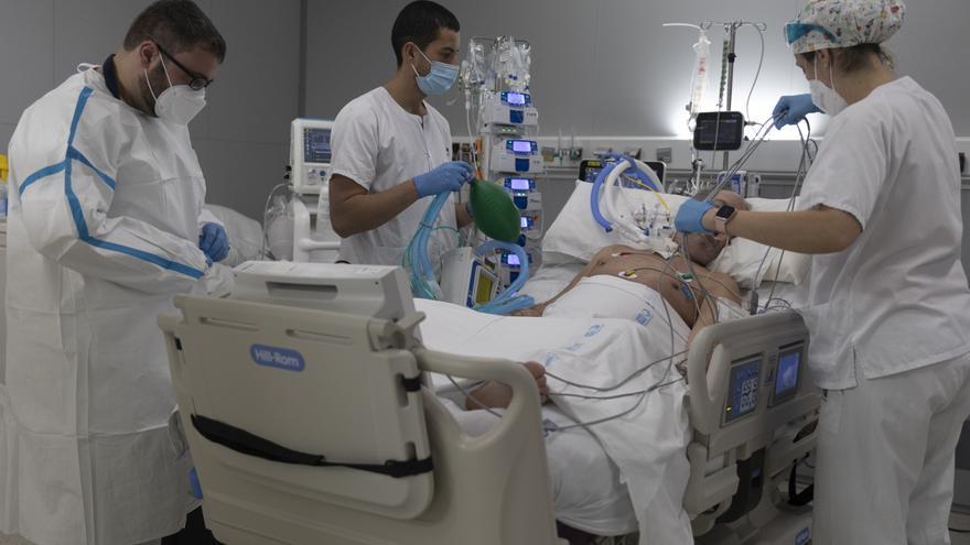 Varios sanitarios alrededor de un paciente ingresado en una UCI COVID