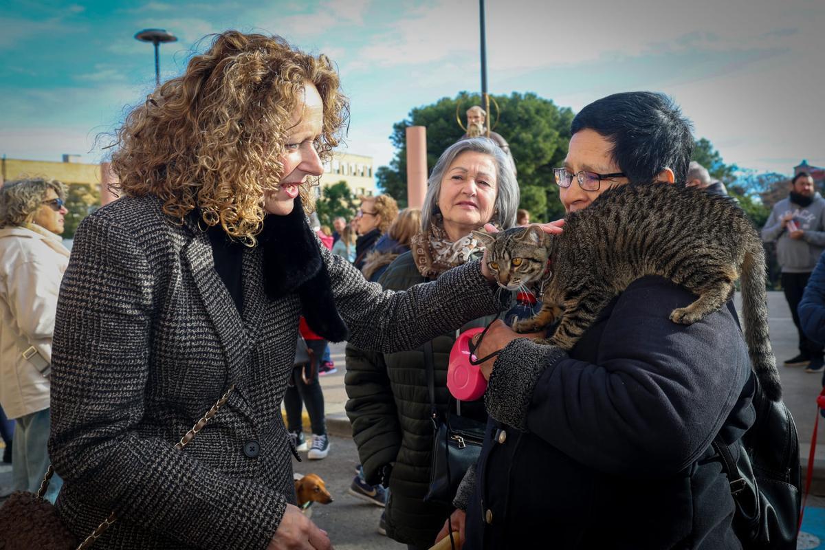 La alcaldesa Folgada acaricida a un gato en la bendición.