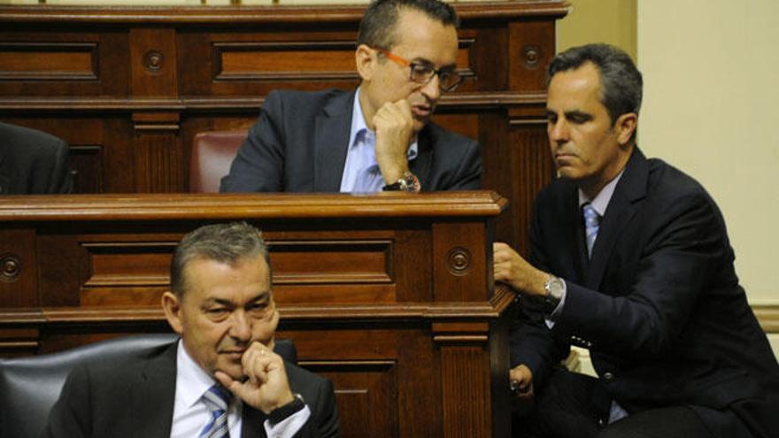Rivero durante el último pleno de la legislatura, detrás Miguel Jorge (PP) agachado, charla con el nacionalista José Miguel Ruano