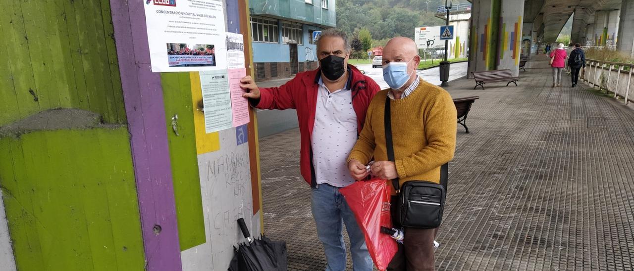 José Luis Sánchez Cuenya (izquierda) y Antonio García , ayer, pegando los carteles para la concentración. | M. Á. G.