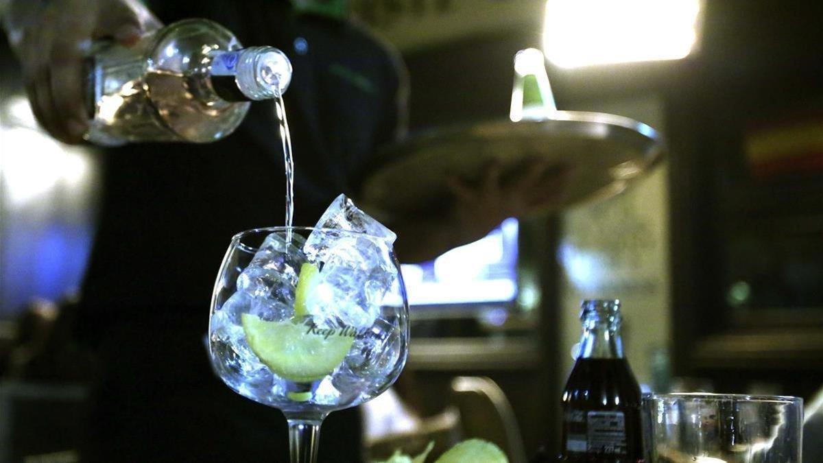 Un camarero sirve una bebida alcohólica en un bar.