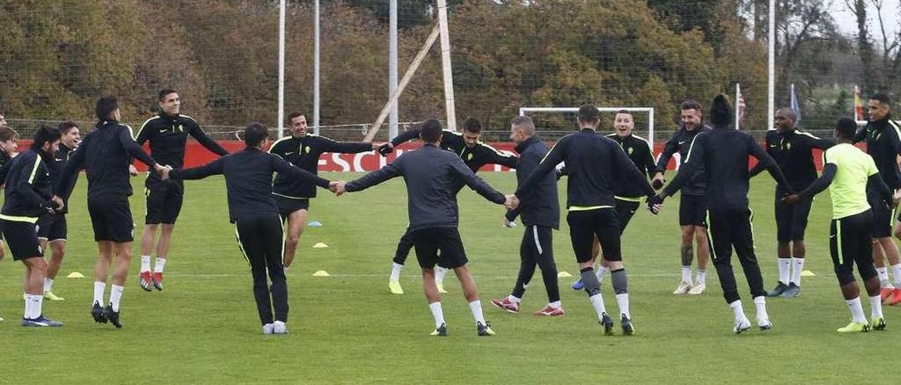 Los jugadores del Sporting, en uno de los ejercicios realizados durante el calentamiento previo al inicio de un entrenamiento en Mareo.