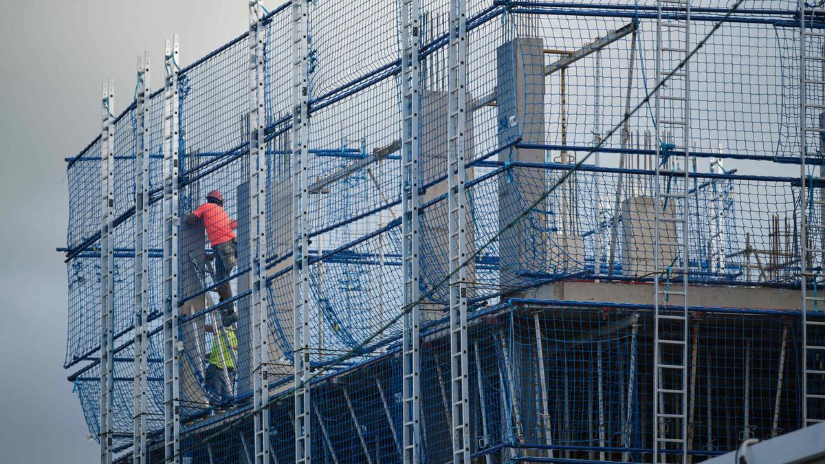 Una pareja de obreros trabaja en el apuntalamiento de un edificio.