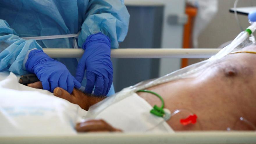 Un sanitario atiende a un paciente de COVID en un hospital de España.