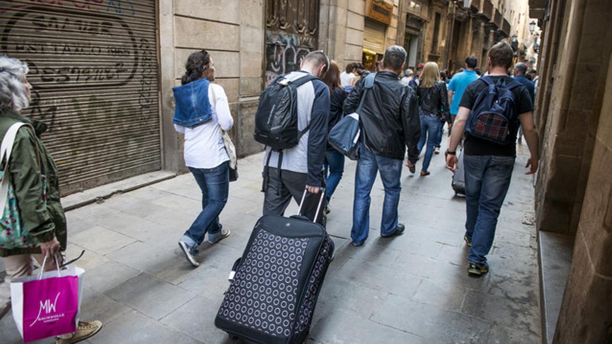 Turistas con maletas en el centro de Barcelona.