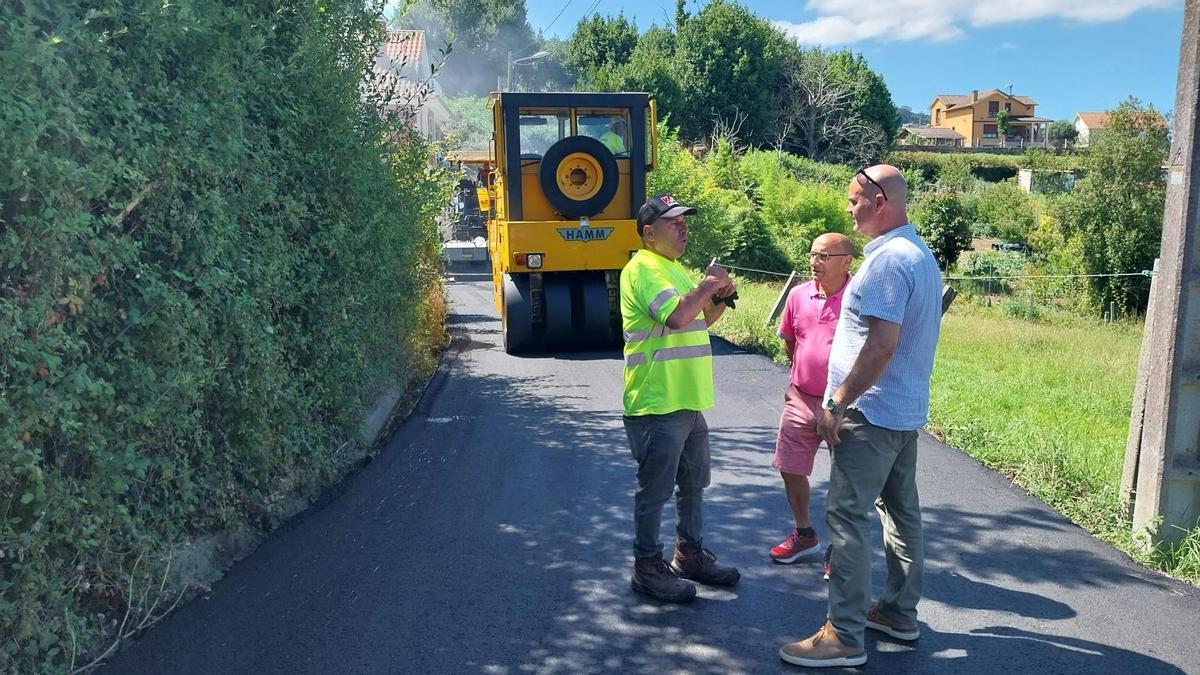 El alcalde de Bueu, Félix Juncal, y el concejal de Mantemento e Reparación de Vías Públicas, Celso Dopazo, este miércoles en la parroquia de Cela con el encargado del asfaltado del vial A Torre-Xoalde-Castrelo.
