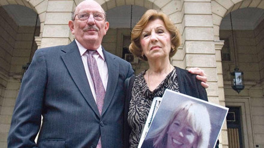 Los padres de la víctima portan, ayer, una fotografía de la joven en la puerta del Palacio de Justicia.