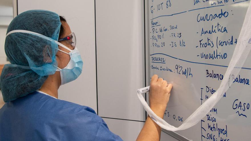 Una professional sanitària pren notes en una pissarra dels tractaments