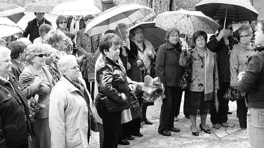 El grupo de mujeres escucha las explicaciones de una guía turística frente a la basílica llanisca.