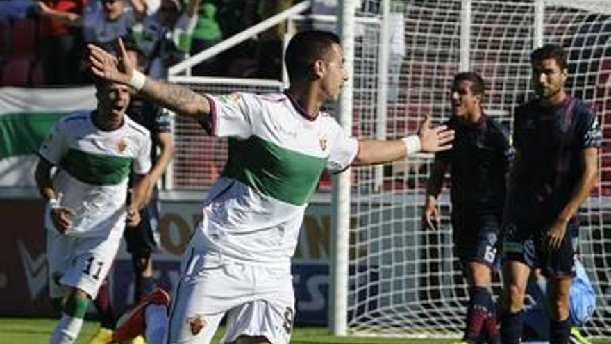 Sergio León, con los brazos abiertos, celebra uno de los goles que le marcó ayer al Huesca.